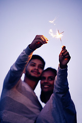 Image showing Couple, sparklers and happy together for night celebration or romance date for love, support and freedom outdoor. Smile, Indian woman and man hugging or quality time to celebrate happiness in Bali
