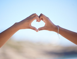 Image showing Hands together, heart sign and outdoor at beach, nature and blue sky in blurred background for love. Couple, hand touch and romantic gesture for bonding, care and support for relationship in Miami