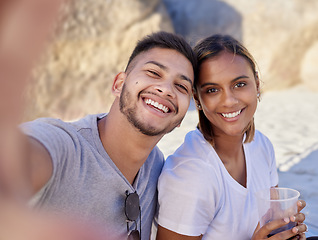 Image showing Selfie, couple of friends and drinks at beach in summer, party and relax holiday for love, care or happiness. Portrait, young man and smile woman taking photo in sunshine, picnic or happy date at sea