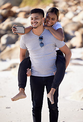 Image showing Couple, piggyback and selfie on the beach to have fun and bond with love and affection. Man, woman and ocean date while taking a mobile photo on the sea sand for romance and tropical holiday