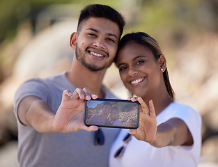 Image showing Happy couple, phone selfie and screen in nature, smile and memory on vacation in summer sunshine. Couple, love and romance with digital picture, smartphone and happiness for social media in Jakarta