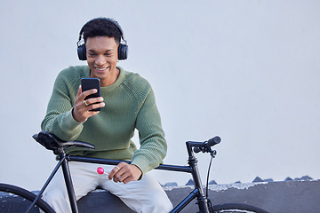 Image showing Black man, bicycle and headphones for travel, social media update and 5g networking on nature or sky mockup for marketing. Student bike, music streaming service and smartphone with advertising space