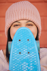 Image showing Skateboard, young face and woman hiding with winter beanie, clothes and gen z fashion, hipster culture and happiness in city. Portrait, happy and shy skater girl, eyes and relax for fun at skate park