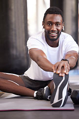 Image showing Fitness, stretching and portrait of black man in gym for exercise, workout and training with earphones. Sports, healthy lifestyle and male athlete getting ready, warm up and stretch legs on floor