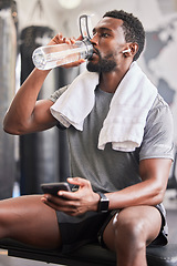 Image showing Water bottle, black man in gym and smartphone for social media after fitness exercise, healthy sports workout and muscle growth. Wellness work out, training motivation and a tired guy drinking water