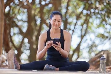 Image showing Fitness, relax and woman in park with phone on break after running, exercise and workout in nature. Sports, wellness and happy girl on smartphone for training blog, health mobile app and social media