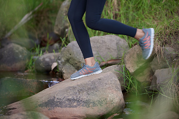 Image showing Fitness, legs or shoes running in nature for training, cardio exercise or workout by a river, water or lake in Amsterdam. Footwear, sneakers or healthy sports girl runner in running shoes on a rock