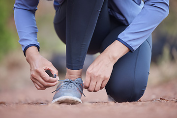 Image showing Fitness, hands and running shoes in preparation for exercise, training or cardio workout in the nature outdoors. Hand of runner tying shoe laces getting ready for run, healthy exercising or trekking