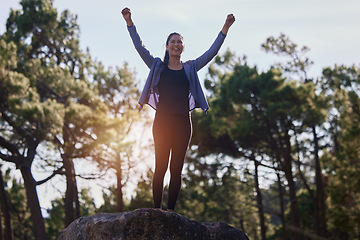 Image showing Hiking, winning and woman celebrating on a rock in a forest for fitness, sport hike in nature with joy. Celebration, success and female athlete hiker with carefree freedom for workout in the woods