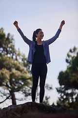 Image showing Fitness, winner and mountain with woman celebrate hiking goal, marathon training and target with success hands sign on a blue sky. Sports, athlete and runner on hill in forest winning triathlon event