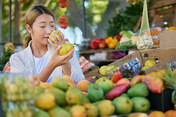 Image showing Fruits, food and woman in Japan market for quality choice, nutrition and healthy shopping in green, eco friendly store. Outdoor marketplace, pear and vegan asian or customer sale, offer and discount