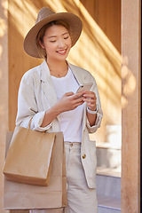 Image showing Woman, shopping bag and phone for communication, ecommerce and online chat about sale, discount and savings while outdoor. Happy customer or asian female with smartphone for banking and retail coupon