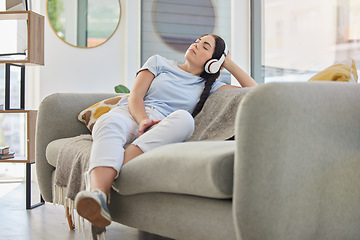 Image showing Woman, relax and music headphones on sofa in house, home or hotel living room for mental health, self care or stress management. Zen, student and person listening to radio, podcast or wellness audio