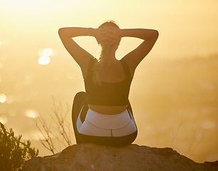 Image showing Relax, sunset and fitness woman on a mountain rock looking at nature view for calm yoga. Workout, zen and back of a pilates athlete with peace, meditation and chakra wellness training outdoor