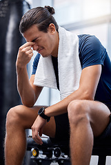 Image showing Man, gym exercise and tired with headache at training, workout or wellness studio with anxiety. Bodybuilder, fitness and burnout while sitting for stress, rest or relax after weightlifting in Toronto