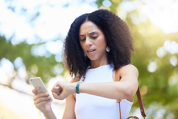 Image showing Black woman, phone and checking time on watch for schedule, appointment or planning in the park. African American female monitoring smart watch for busy day in the outdoors with smartphone in nature