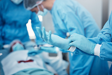 Image showing Hospital, surgery and doctors in team with gloves, ppe and safety to help patient on bed with stomach cancer. Doctor teamwork group, medical operation and lifesaving collaboration for healthcare