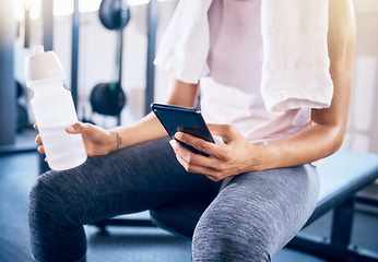 Image showing Fitness, phone or hands on social media at gym with a water bottle relaxing in training, exercise or workout break. Digital, internet or healthy girl texting, typing or searching for online content