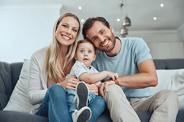 Image showing Happy, smile and portrait of a family on a sofa relaxing, bonding and holding their child at their home. Mother, father and baby boy sitting in the living room together with love, care and happiness.