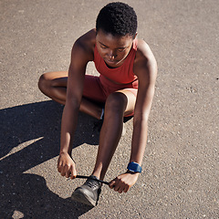 Image showing Running, fitness and tie shoes with black woman in road for cardio, workout and training. Sports, ready and performance with girl runner fixing sneakers for jogging, start and stamina endurance