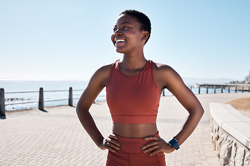 Image showing Black woman runner, smile and happy by sea promenade for health, fitness and summer body goals. Happy running workout, training and exercise by ocean for wellness, muscle and development in Sydney