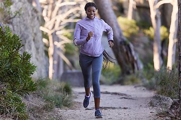 Image showing Fitness, nature and black woman running for exercise with endurance, focus and health in a forest. Sports, athlete and African lady doing cardio workout or training for race, marathon or competition.