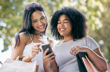 Image showing Black woman, shopping and friends with smartphone outdoors for social media retail sales, discount and online fashion deal promo. Planning ecommerce, website shop and browsing internet store together