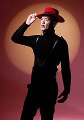 Image showing Fashion, style and man with vitiligo in a studio with a grungy, edgy and goth outfit with an orange light. Stylish, aesthetic and cool male model with a skin depigmentation posing by a red background