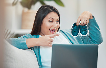 Image showing Woman, laptop and video call, baby shoes and pregnant while talking, excited or virtual communication in home. Happy female, pregnancy or mother with happiness, pointing and video conference in house