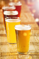 Image showing Alcohol, beer and glasses at a bar table for party, club and happy hour promotion, sale and commercial background for event. Social lifestyle, drink and group of ale glasses at pub for cocktail sale