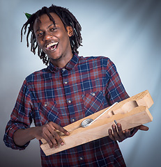 Image showing Portrait, prop and happy man holding giant peg looking cheerful on a grey studio background. Face, front and laughing, joyful african american male holding a clothes peg on a studio backdrop