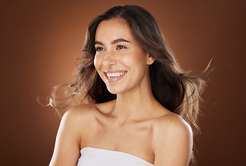 Image showing Hair, beauty and skincare with a model woman in studio on a brown background for natural or keratin treatment. Face, haircare and salon with an attractive young female posing to promote a product