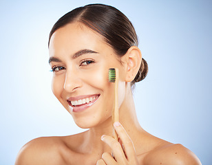 Image showing Face portrait, dental and woman with toothbrush in studio isolated on a blue background. Oral wellness, veneers and happy female model holding product for brushing teeth, cleaning and oral hygiene.