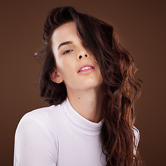 Image showing Portrait, hair and beauty with a model woman in studio on a brown background for natural or keratin treatment. Face, hair care and luxury with an attractive young female posing to promote haircare