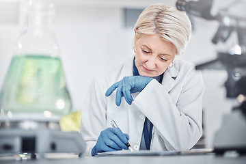Image showing Science, research and senior woman writing notes on documents in laboratory. Innovation, thinking and elderly female scientist researching, recording and write experiment results, analysis or report.