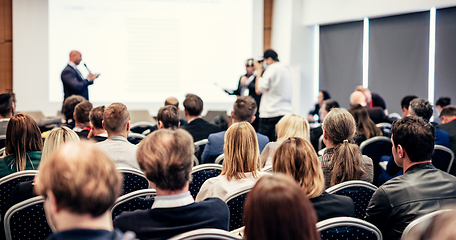 Image showing I have a question. Group of business people sitting in conference hall. Businessman raising his arm. Conference and Presentation. Business and Entrepreneurship