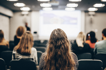 Image showing Speaker giving a talk in conference hall at business event. Rear view of unrecognizable people in audience at the conference hall. Business and entrepreneurship concept.