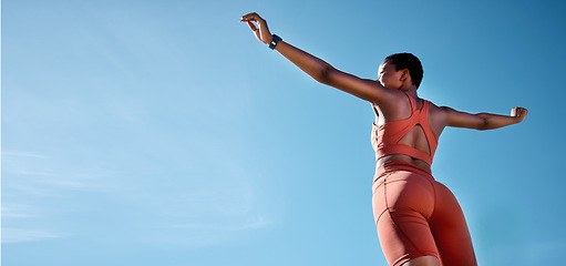 Image showing Woman, arms up or fitness success on blue sky background in workout, training or exercise goals for healthcare or cardiovascular wellness. Low angle runner, sports athlete or hands raised with mockup