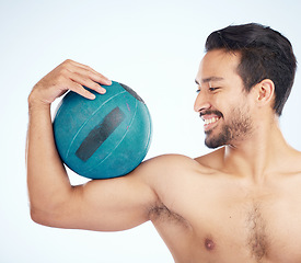 Image showing Face, fitness and man with medicine ball for exercise and health in studio on a blue background. Sports, training and happy male athlete with ball weight for strength, exercising and muscle power.