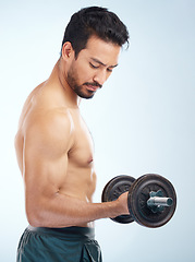 Image showing Man, fitness and dumbbell in studio for muscle, wellness and self care by blue background with focus. Model, bodybuilder workout and training for health, body or development with exercise by backdrop