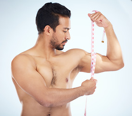 Image showing Fitness, body and man with tape measure for biceps in studio on a blue background. Sports, exercise goals and male measuring arm for training, workout or muscle growth progress, results or target.
