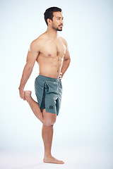 Image showing Fitness, health and man stretching leg in studio isolated on a blue background mock up. Sports, body wellness and young male athlete stretch, warm up and preparing for workout, exercise and training.
