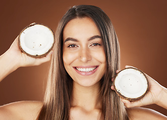 Image showing Woman, skincare and coconut in studio, happy or smile for self care, nutrition or cosmetic health. Model, skin wellness and fruit for oil, moisturizer or cosmetics background for natural radiant glow