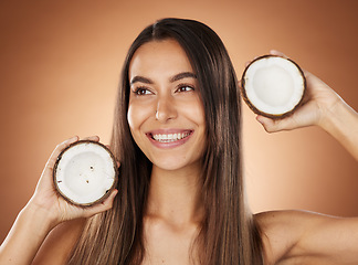 Image showing Woman, skincare and coconut in studio, happy or smile for self care, nutrition or cosmetic health. Model, skin wellness and fruit for oil, moisturizer or cosmetics background for natural radiant glow