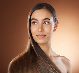 Image showing Hair, beauty and skincare with a model woman in studio on a brown background for natural or keratin treatment. Face, haircare and salon with an attractive young female posing to promote a product