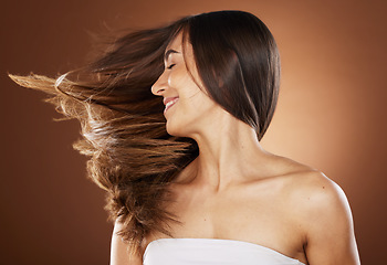 Image showing Hair, beauty and skincare with a model woman in studio on a brown background for natural or keratin treatment. Face, haircare and salon with an attractive young female posing to promote a product