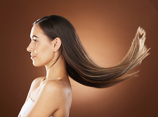 Image showing Hair, beauty and skincare with a model woman in studio on a brown background for natural or keratin treatment. Face, haircare and salon with an attractive young female posing to promote a product