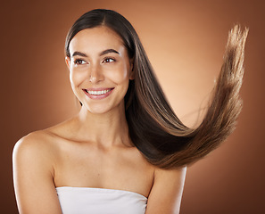 Image showing Hair, beauty and skincare with a model woman in studio on a brown background for natural or keratin treatment. Face, haircare and salon with an attractive young female posing to promote a product