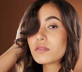 Image showing Woman, face skincare or curly hairstyle on brown studio background in color dye advertising, self love or Brazilian keratin treatment. Portrait, beauty model or brunette waves and natural makeup glow