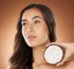 Image showing Coconut skincare beauty, woman and studio for health, wellness and natural radiant glow by backdrop. Model, face and fruit for nutrition, cosmetics or coconut oil for skin moisturizer by background